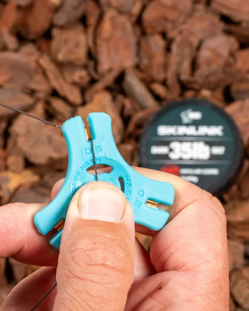 Stripping coating from a coated braid hooklink using a stripping tool.