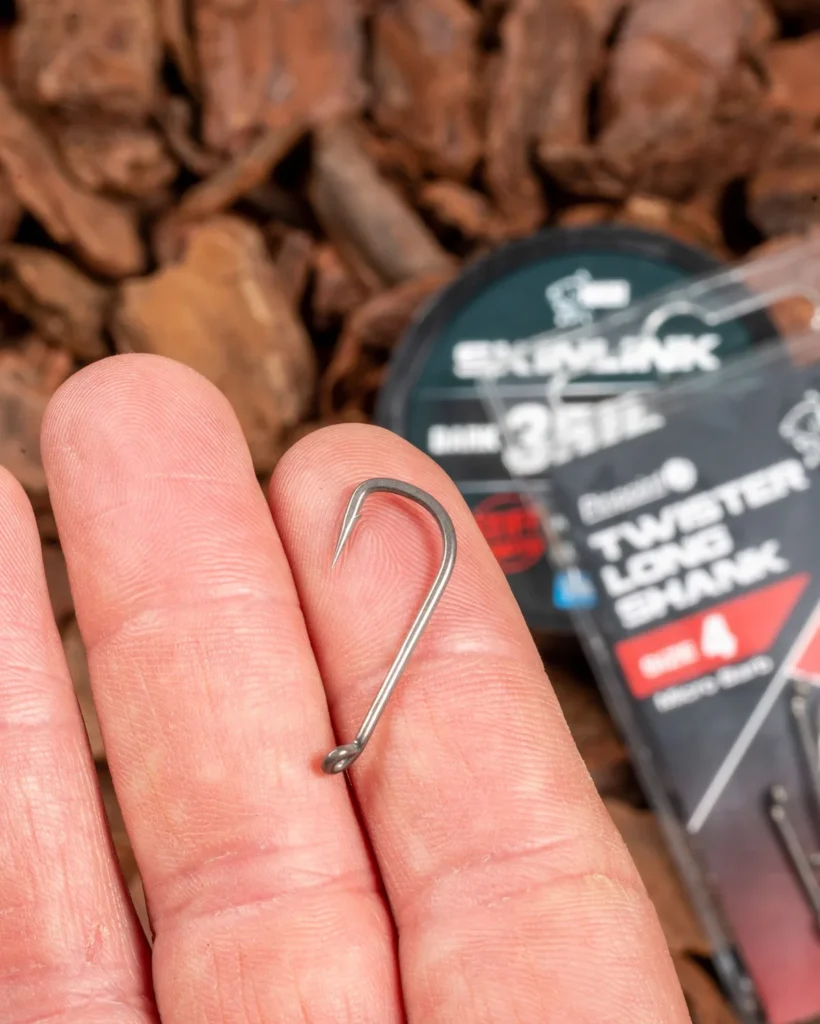 Carp hook shown on fingertips before tying the Slip D Rig.